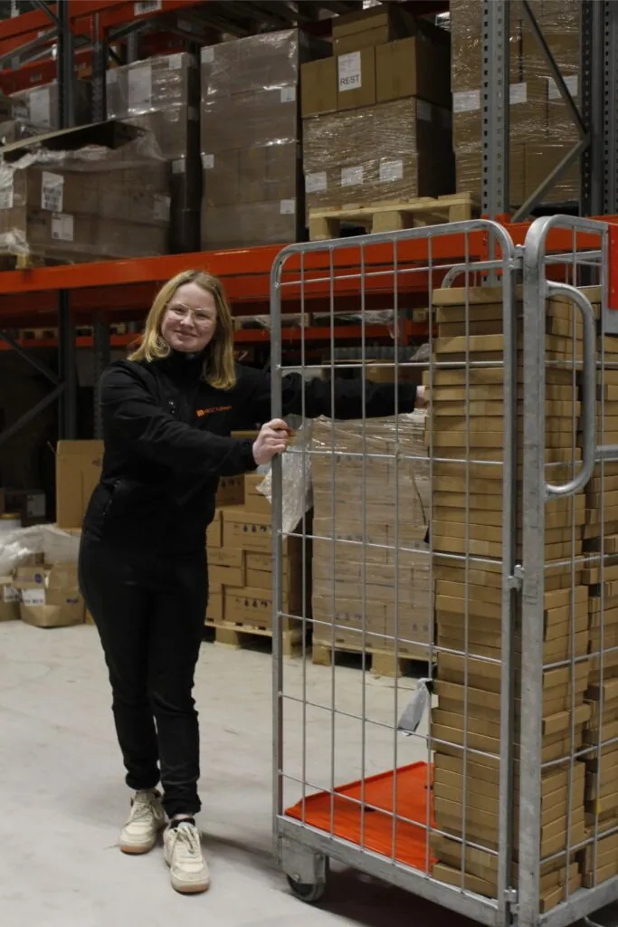 Medewerker van HEGO Fulfilment bij een rolcontainer met pakketten